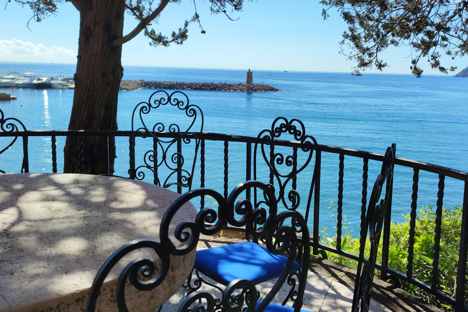Mesa y sillas en un balcón con vistas al mar